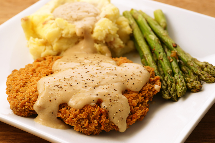 A plate of fried chicken, mashed potatoes and asparagus