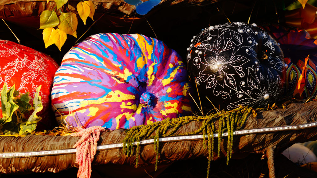 Colorful pumpkins on the fair, painted halloween pumpkins, autumn background