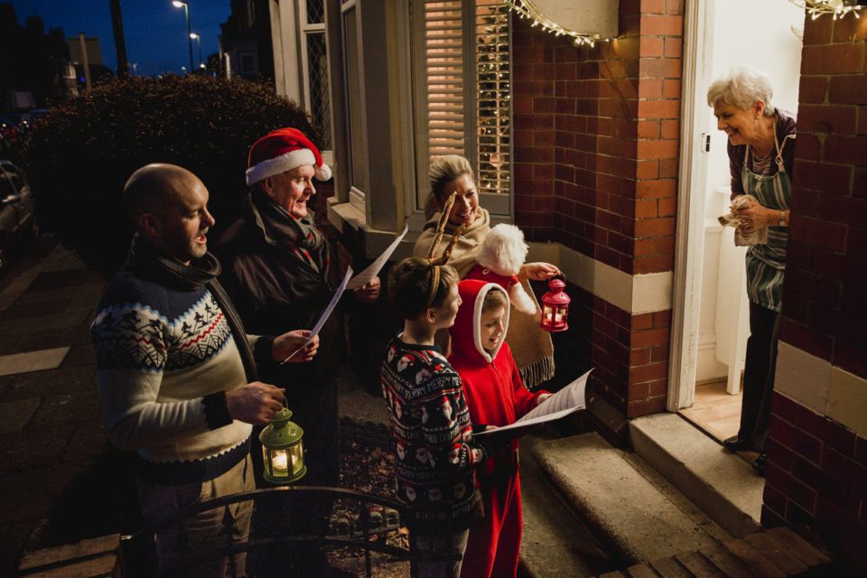 Family Singing Carols in Christmas themed attire